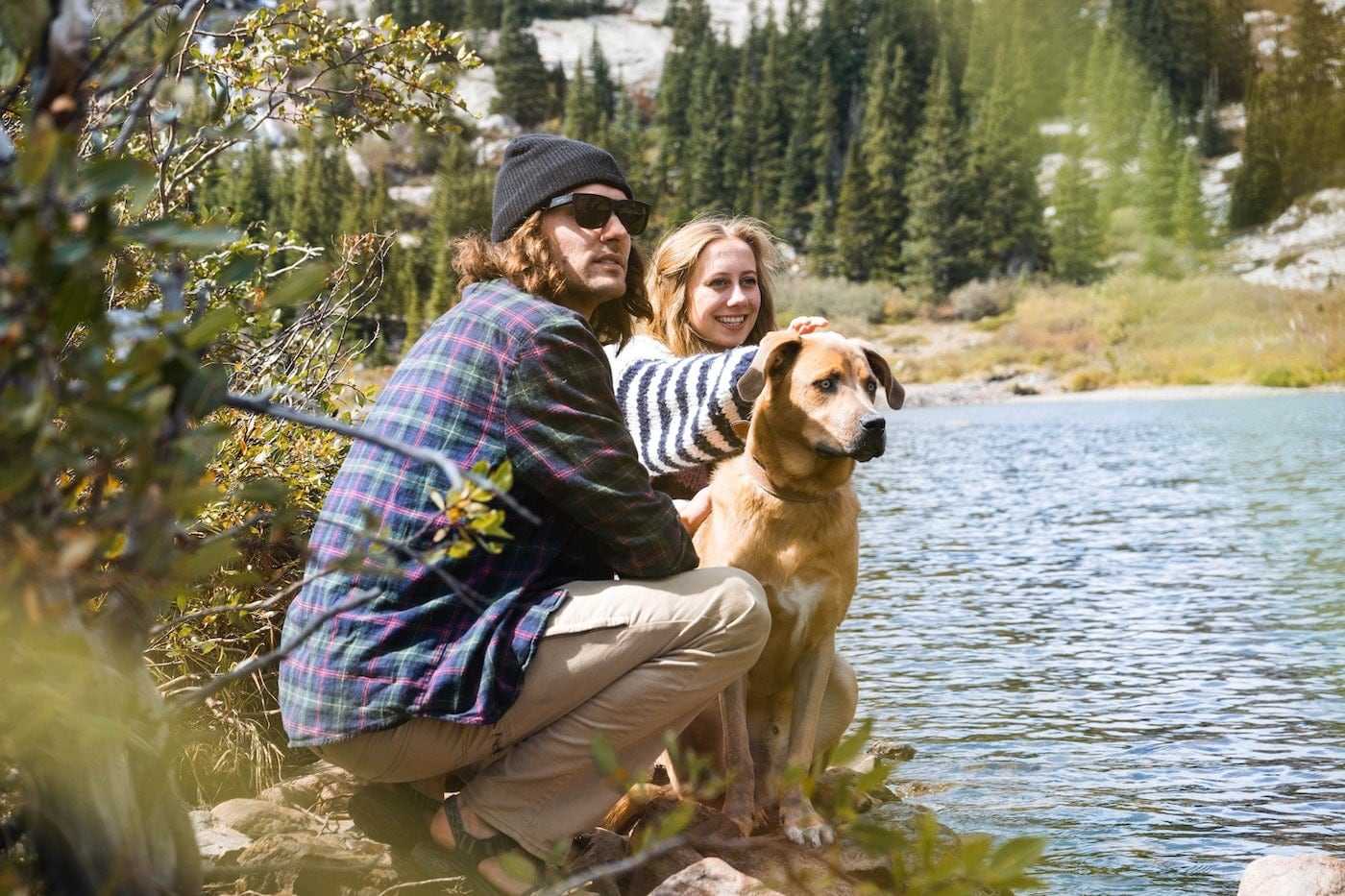 A couple with their dog outdoors.